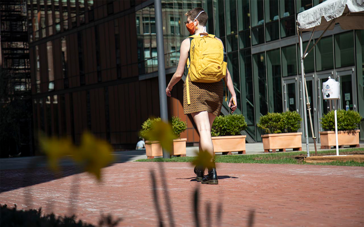 A student wearing a mask walks through Barnard's campus