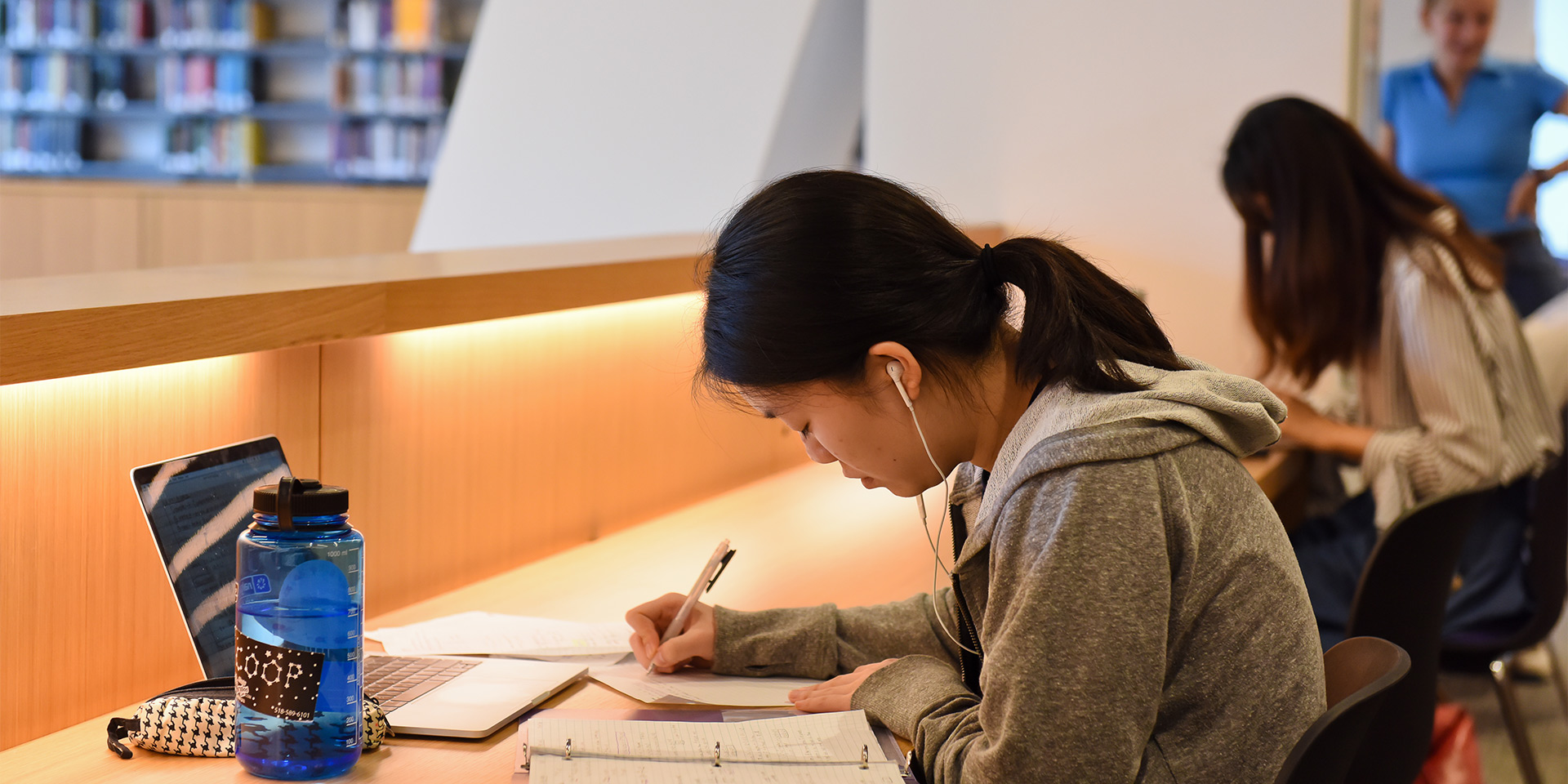 Student studying with laptop and earbuds