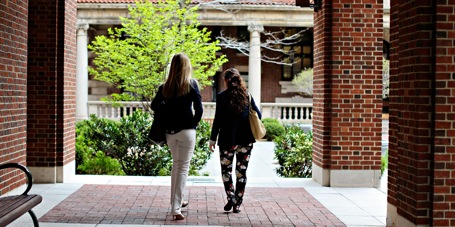 Two students walking toward the quad